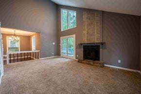 Fayettevile house for rent - A living room with a fireplace and a large window.