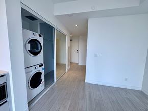Toronto apartment for rent - A modern laundry room with a washer and dryer built into the wall.