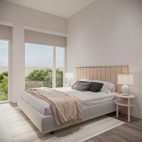 Ottawa apartment for rent - A bedroom with a large bed and a view of the trees outside the window.