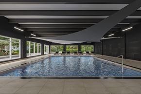 Ottawa apartment for rent - A large indoor swimming pool with a metal ladder on the right side.