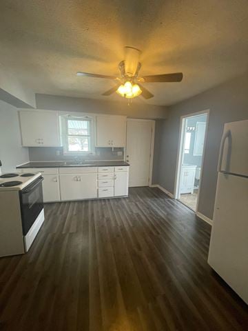 Lima apartment for rent - A kitchen with white cabinets and a black stove top oven.