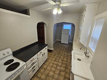 Lima apartment for rent - A kitchen with a black countertop and white appliances.