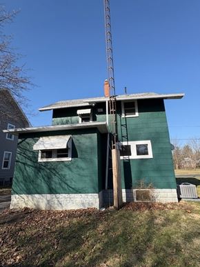 Lima house for rent - A green building with a white window and a brown door.