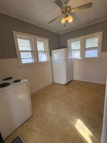 Lima house for rent - A kitchen with a white refrigerator, a white dishwasher, and a ceiling fan.