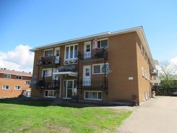 Pembroke apartment for rent - A large brick building with a balcony on the second floor.