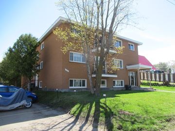 Pembroke apartment for rent - A red brick house with a tree in front of it.