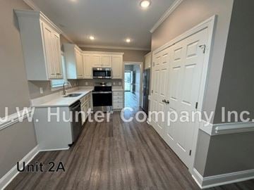 Wilson apartment for rent - A kitchen with white cabinets and a black stove top oven.