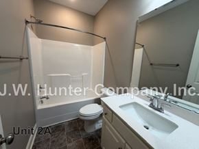 Wilson apartment for rent - A bathroom with a toilet, sink, and shower.