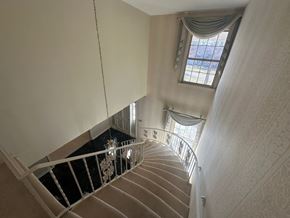 Knoxville, Tn house for rent - A staircase with a metal railing and a window with curtains.