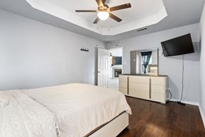 Killeen house for rent - A bedroom with a bed, a dresser, and a ceiling fan.