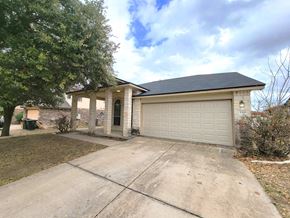 Killeen house for rent - A house with a grey garage door and a black roof.