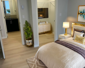 Calgary apartment for rent - A bedroom with a large bed and a television in the background.
