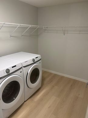 Calgary apartment for rent - Two white front load washing machines in a laundry room.