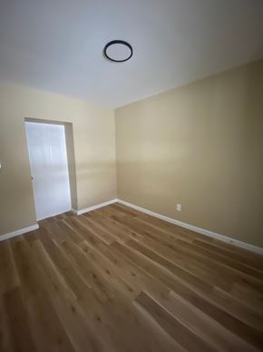 Louisville house for rent - A room with a wooden floor and a white door.