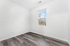Gary house for rent - A room with a window showing a house and trees outside.