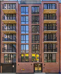 Queens apartment for rent - A red brick building with balconies on the second floor.