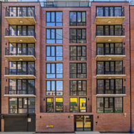 Queens apartment for rent - A red brick building with balconies on the second floor.