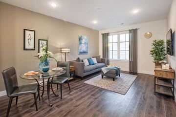 Waldwick apartment for rent - A living room with a glass table and chairs, a grey sofa, a blue armchair, and a wooden coffee table.