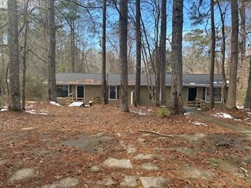 Dallas apartment for rent - A house surrounded by trees in a wooded area.