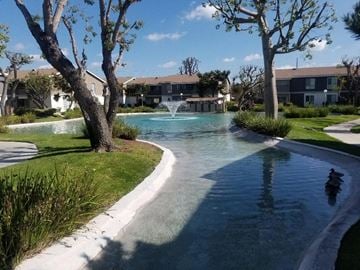 Santa Ana apartment for rent - A small waterfall in a garden with a building in the background.