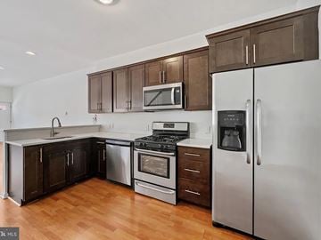 Baltimore house for rent - A kitchen with a stove top oven and a refrigerator.