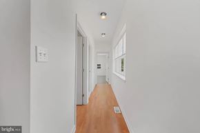 Baltimore house for rent - A long hallway with a light on the ceiling and a door at the end.