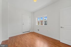 Baltimore house for rent - A room with a white door and a window showing a view of buildings.