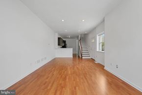 Baltimore house for rent - A spacious room with wooden floors and a staircase.