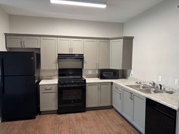 Valdosta apartment for rent - A kitchen with black appliances and wooden floors.