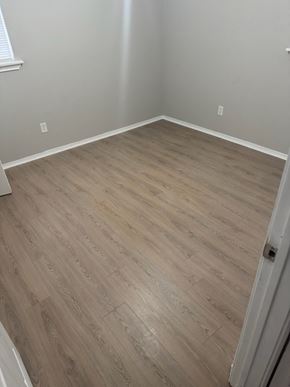 Houston house for rent - A room with a wooden floor and a white door.