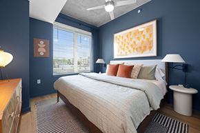 Raleigh apartment for rent - A bedroom with a bed, nightstand, and a painting on the wall.
