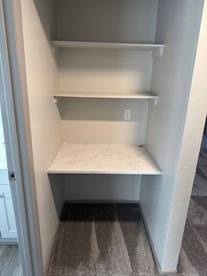 Fountain apartment for rent - A white pantry with a marble countertop and a striped carpet.