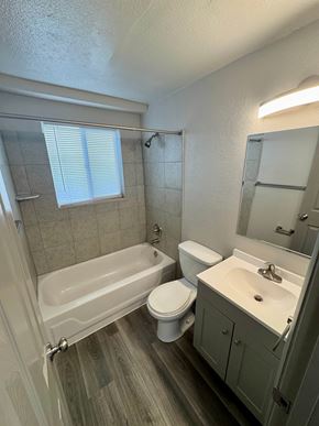Fountain apartment for rent - A white bathroom with a tub, toilet, and sink.