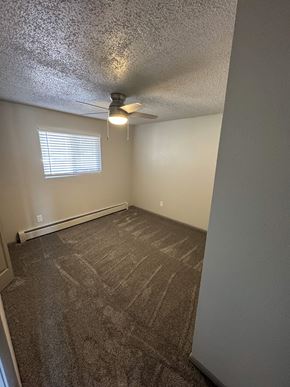 Fountain apartment for rent - A room with a carpeted floor and a ceiling fan.