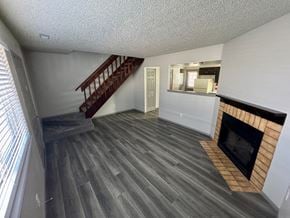 Colorado Springs apartment for rent - A living room with a fireplace and a staircase.