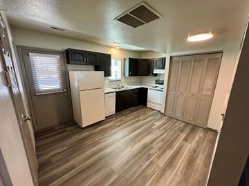 Colorado Springs apartment for rent - A kitchen with a white refrigerator and wooden floors.