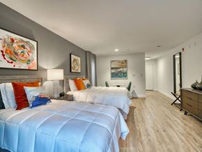Olney apartment for rent - A bedroom with two beds and a painting on the wall.