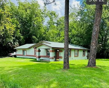 Jacksonville house for rent - A house with a green lawn and trees in the background.