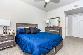 Houston apartment for rent - A bedroom with a blue comforter on the bed.