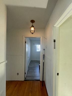 Mount Airy house for rent - A hallway with a wooden floor and a light hanging from the ceiling.