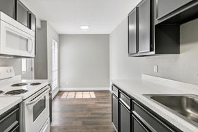 Beaumont apartment for rent - A modern kitchen with white appliances and black cabinets.