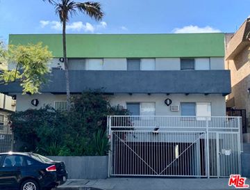 West Hollywood apartment for rent - A black car is parked in front of a house with a green roof.