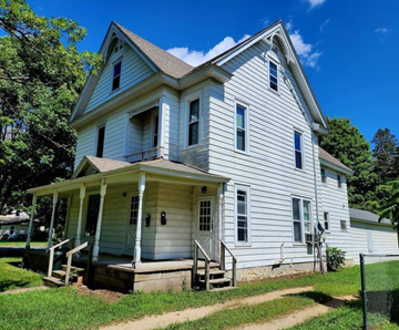 Menomonie house for rent - A white two-story house with a porch.