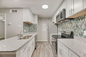 Dallas apartment for rent - A modern brick building with a green lawn in front.