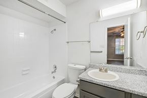 Fort Worth apartment for rent - A kitchen with a black stove top oven and a black microwave above it.