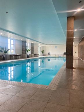 Saint-Laurent apartment for rent - A large indoor swimming pool with a tiled floor and a high ceiling.