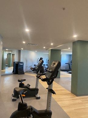 Saint-Laurent apartment for rent - A gym with a variety of exercise equipment including treadmills, stationary bikes, and elliptical machines.