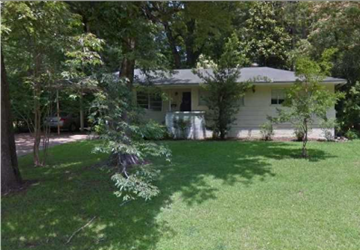 Jackson house for rent - A house with a white fence and a green lawn.