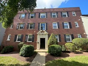 Washington apartment for rent - A red brick building with a white door and black shutters.