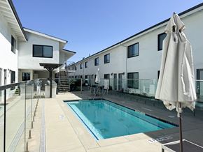 Torrance apartment for rent - A white building with a pool in front.